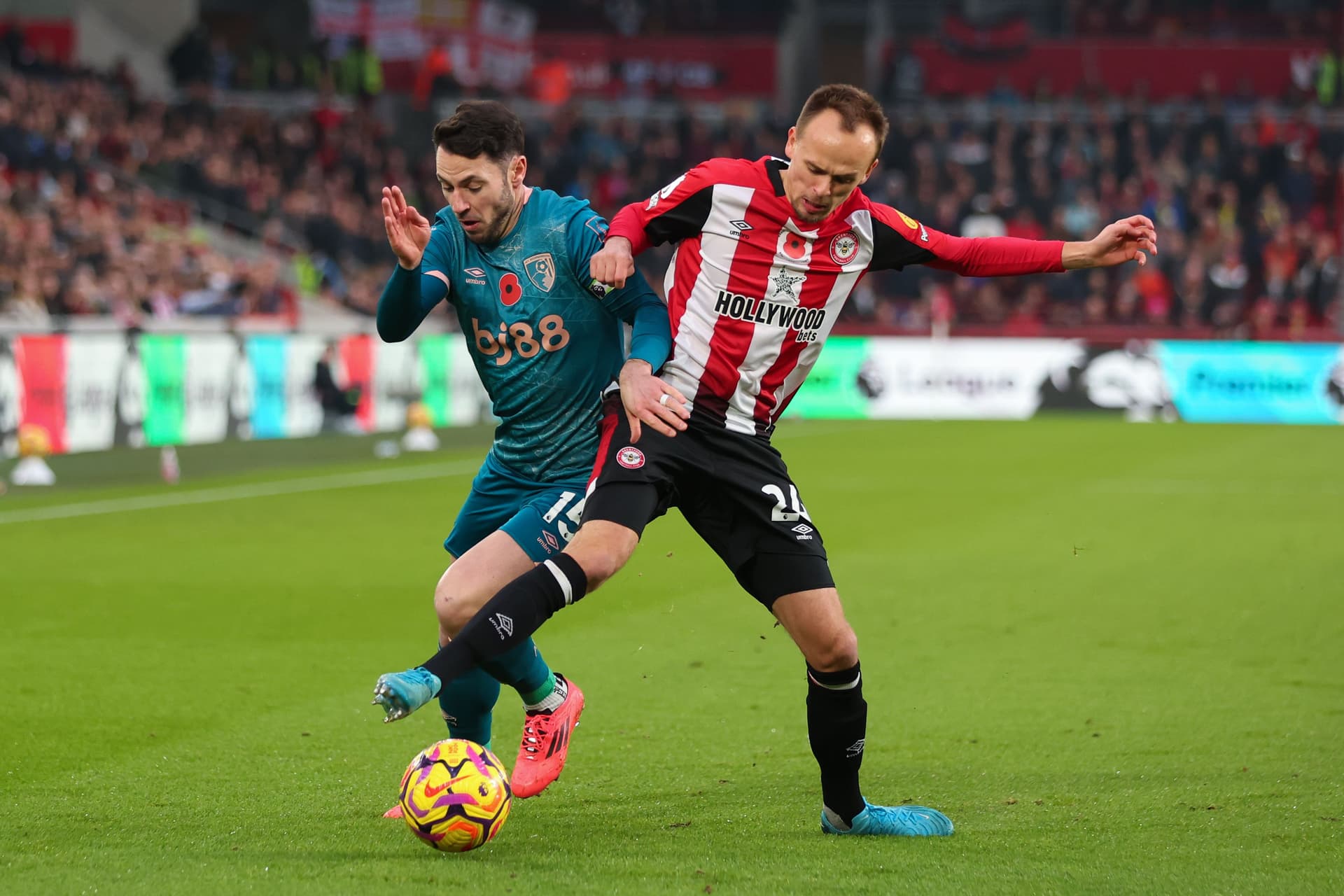 Adam Smith of AFC Bournemouth is challenged by Mikkel Damsgaard of Brentford