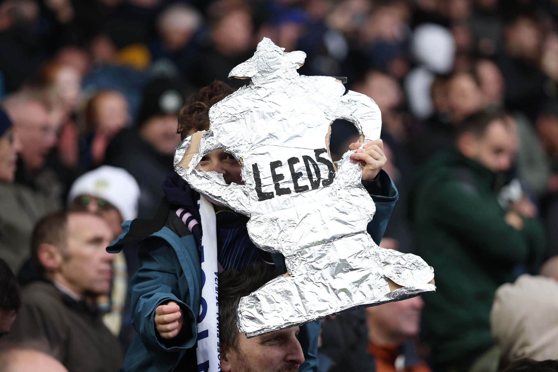 A young fan of Leeds United holds up a tin foil replica of the Emirates FA Cup trophy